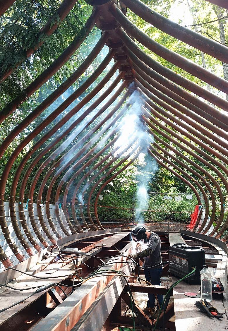 Welder fabricating a curved structural steel arch